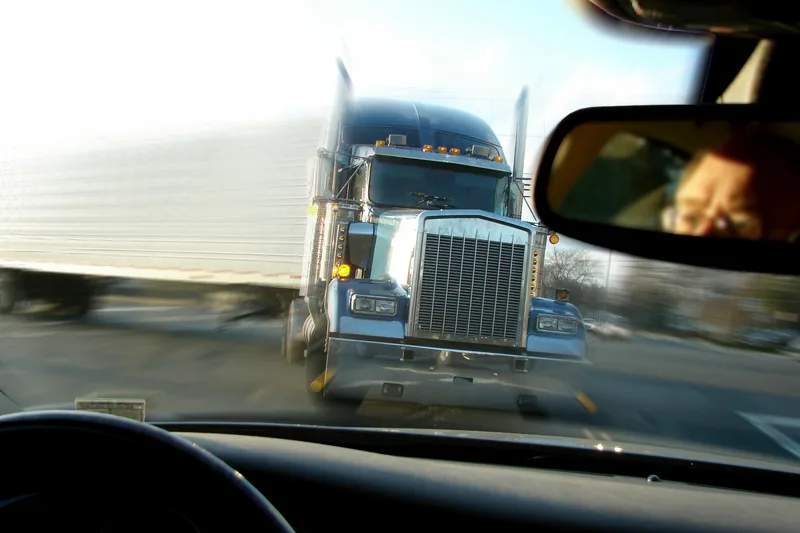 Semi-truck bearing down on vehicle from driver's perspective